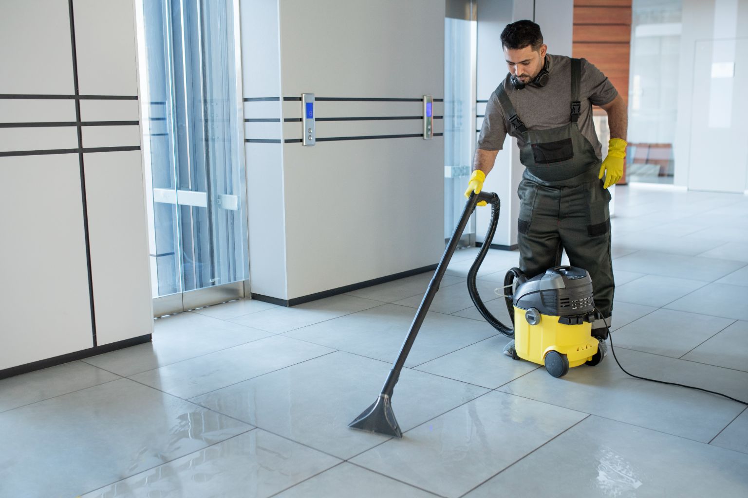 Professionnelle utilisant un aspirateur pour nettoyer un sol